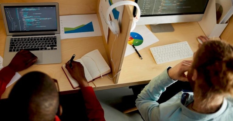 Dois desenvolvedores trabalham em seus workstations